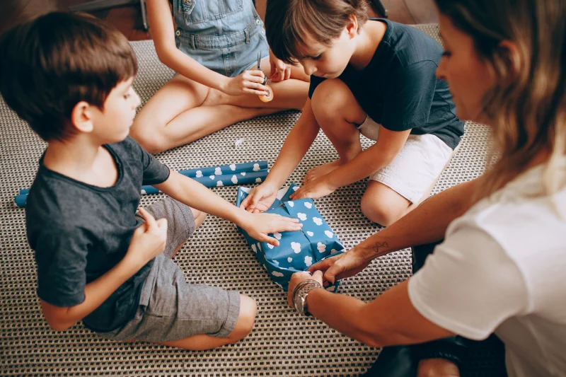 Family wrapping gifts at home.